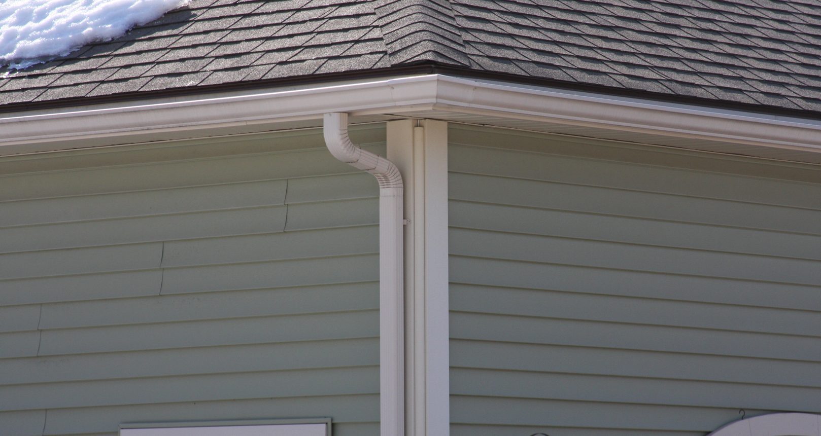 White Gutters & Snow-Covered Roofing Surface